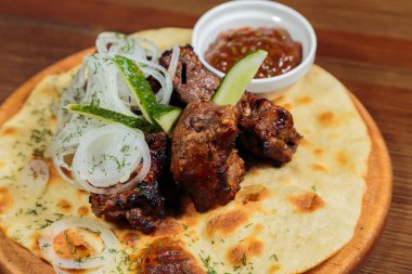 Ahşap bir tablete iştah açıcı Barbekü pişmiş sebze ve sos ile servis.