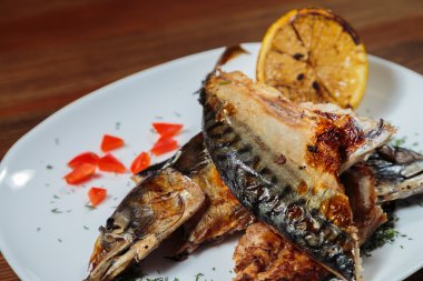 Beyaz bir plaka üzerinde ızgara sebzeli uskumru füme.