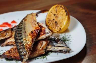 Beyaz bir plaka üzerinde ızgara sebzeli uskumru füme.