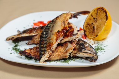 Beyaz bir plaka üzerinde ızgara sebzeli uskumru füme.