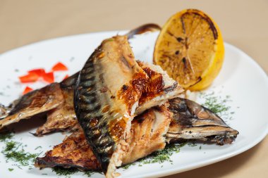 Beyaz bir plaka üzerinde ızgara sebzeli uskumru füme.