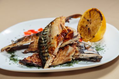 Beyaz bir plaka üzerinde ızgara sebzeli uskumru füme.