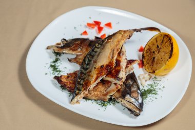 Beyaz bir plaka üzerinde ızgara sebzeli uskumru füme.