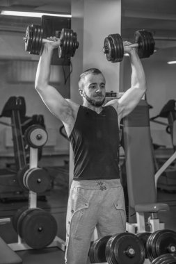 Adam jimnastik salonu. Halter alıştırmalar kılıyor. Spor, güç, halter, gerginlik, egzersiz - sağlıklı bir yaşam tarzı kavramı. Fitness ve spor hakkında makale.