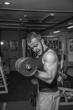Adam jimnastik salonu. Halter alıştırmalar kılıyor. Spor, güç, halter, gerginlik, egzersiz - sağlıklı bir yaşam tarzı kavramı. Fitness ve spor hakkında makale.