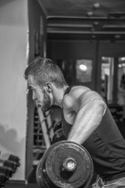 Adam jimnastik salonu. Halter alıştırmalar kılıyor. Spor, güç, halter, gerginlik, egzersiz - sağlıklı bir yaşam tarzı kavramı. Fitness ve spor hakkında makale.