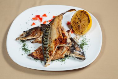 Beyaz bir plaka üzerinde ızgara sebzeli uskumru füme.