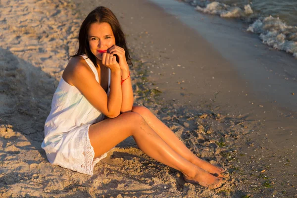 A jovem menina bonita em um vestido branco na praia. Foto menina bonita na praia. Menina posando de forma sedutora. Foto para viagens e revistas sociais, cartazes e sites . — Fotografia de Stock