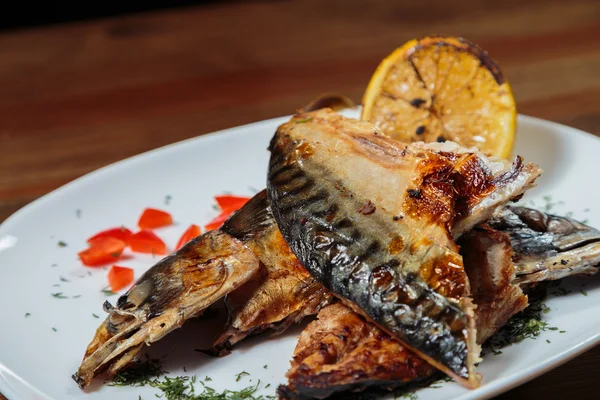 Beyaz bir plaka üzerinde ızgara sebzeli uskumru füme.