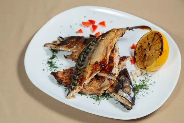 Beyaz bir plaka üzerinde ızgara sebzeli uskumru füme.