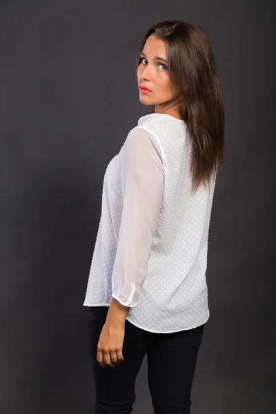 Stylishly dressed young business lady. The image of a beautiful young business lady. Girl in black pants and a white shirt on a dark background. Photo for fashion and social magazines, websites. — Stock Photo, Image