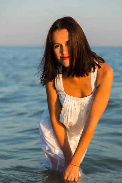 La jeune belle fille en robe blanche sur la plage. Photo belle fille sur la plage. Fille posant de manière séduisante. Photo pour magazines de voyage et sociaux, affiches et sites web . — Photo