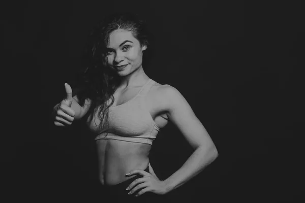 A bela menina de esportes em um fundo escuro . — Fotografia de Stock