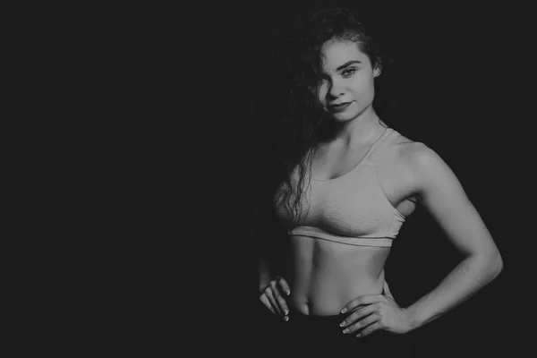 Das schöne Sportmädchen auf dunklem Hintergrund. — Stockfoto