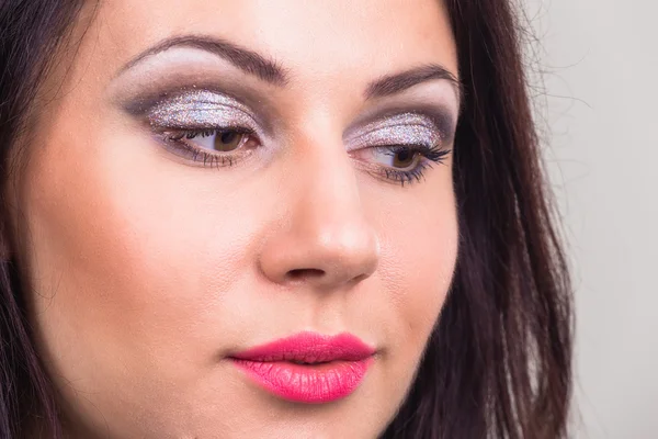 Portret van de schoonheid van een mooi meisje. Heldere feestelijke make-up, glitter, glitters, felle lippenstift. — Stockfoto