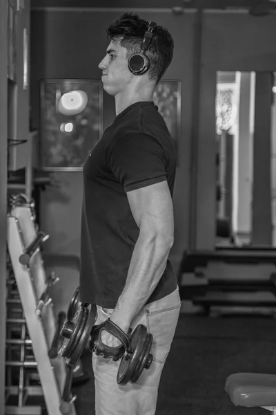 Hombre en el gimnasio. El hombre hace ejercicios de pesas. El deporte, el poder, las pesas, la tensión, el ejercicio - el concepto de un estilo de vida saludable. Artículo sobre fitness y deportes . —  Fotos de Stock