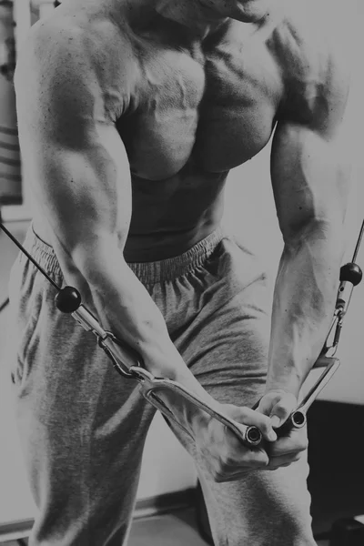 Сильный мускулистый человек делает упражнения в спортзале . — стоковое фото
