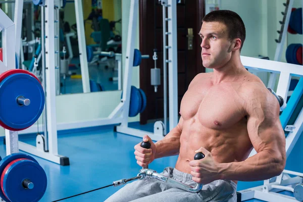 Homem musculoso forte fazendo exercícios no ginásio . — Fotografia de Stock