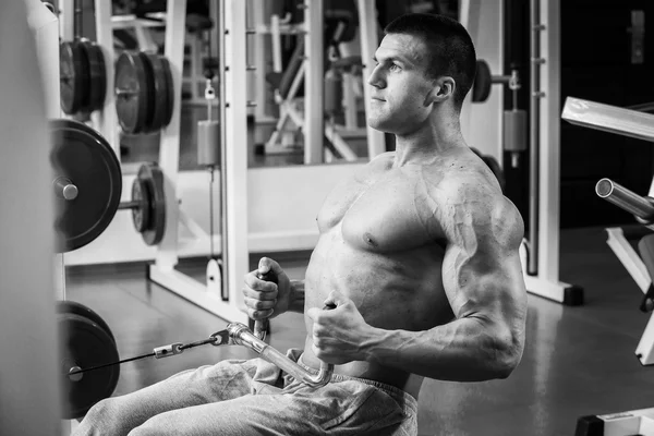 Stark muskulös man göra övningar i gymmet. — Stockfoto