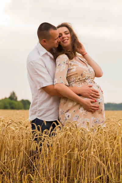 Man en vrouw te wachten kind. Vrolijke en spannend moment. Jong koppel in een tarweveld. Oprechte gevoelens. Tederheid en liefde. Mooi landschap. — Stockfoto