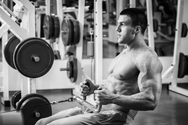 Сильний м'язистий чоловік робить вправи в тренажерному залі . — стокове фото
