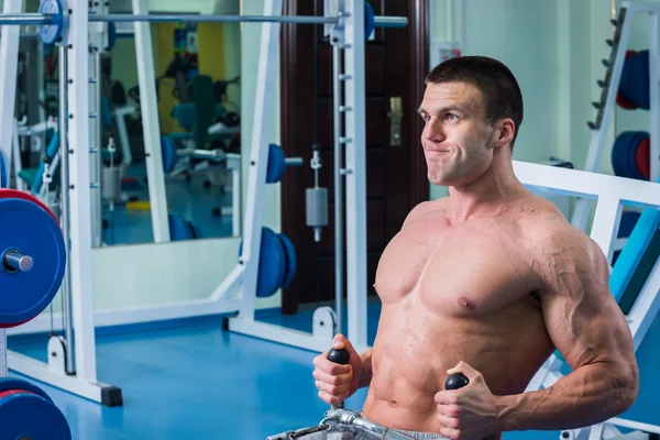 Fuerte hombre muscular haciendo ejercicios en el gimnasio . — Foto de Stock
