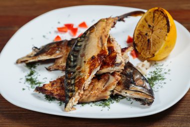 Beyaz bir plaka üzerinde ızgara sebzeli uskumru füme.