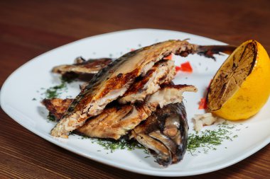 Beyaz bir plaka üzerinde ızgara sebzeli uskumru füme.