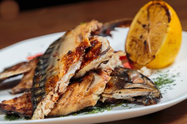 Beyaz bir plaka üzerinde ızgara sebzeli uskumru füme.