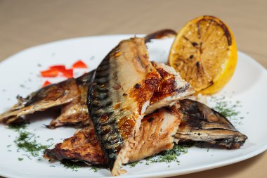 Beyaz bir plaka üzerinde ızgara sebzeli uskumru füme.