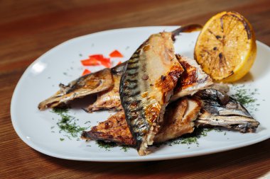 Beyaz bir plaka üzerinde ızgara sebzeli uskumru füme.