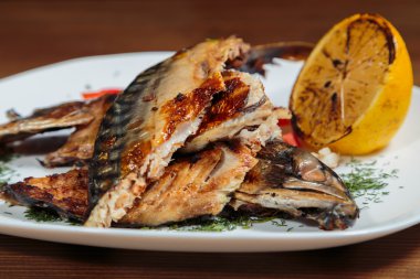 Beyaz bir plaka üzerinde ızgara sebzeli uskumru füme.