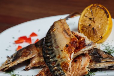 Beyaz bir plaka üzerinde ızgara sebzeli uskumru füme.