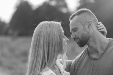 Siyah ve beyaz fotoğraf motorcu çift bir motosiklet alanında.