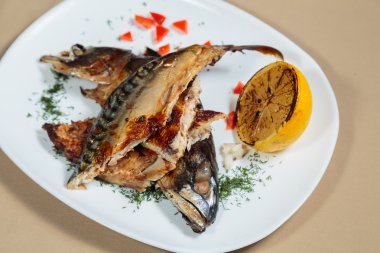 Beyaz bir plaka üzerinde ızgara sebzeli uskumru füme.