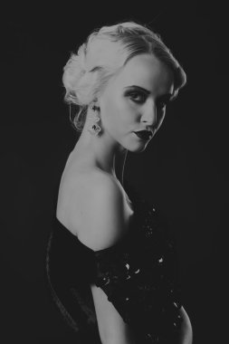 20'li yaşlarda bir kız güzel romantik görüntü stili. Güzel sarışın karanlık bir arka plan üzerinde şık bir elbise içinde. Profesyonel makyaj ve Takı Tasarım. Moda dergileri, afiş ve Web siteleri için fotoğraf.