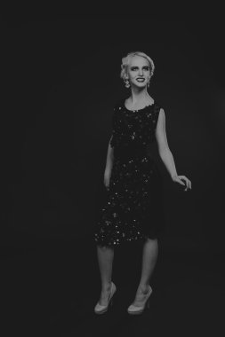 20'li yaşlarda bir kız güzel romantik görüntü stili. Güzel sarışın karanlık bir arka plan üzerinde şık bir elbise içinde. Profesyonel makyaj ve Takı Tasarım. Moda dergileri, afiş ve Web siteleri için fotoğraf.