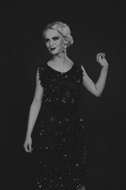 20'li yaşlarda bir kız güzel romantik görüntü stili. Güzel sarışın karanlık bir arka plan üzerinde şık bir elbise içinde. Profesyonel makyaj ve Takı Tasarım. Moda dergileri, afiş ve Web siteleri için fotoğraf.