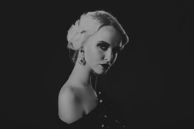 20'li yaşlarda bir kız güzel romantik görüntü stili. Güzel sarışın karanlık bir arka plan üzerinde şık bir elbise içinde. Profesyonel makyaj ve Takı Tasarım. Moda dergileri, afiş ve Web siteleri için fotoğraf.