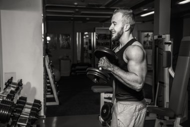 Adam jimnastik salonu. Halter alıştırmalar kılıyor. Spor, güç, halter, gerginlik, egzersiz - sağlıklı bir yaşam tarzı kavramı. Fitness ve spor hakkında makale.