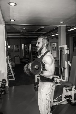 Adam jimnastik salonu. Halter alıştırmalar kılıyor. Spor, güç, halter, gerginlik, egzersiz - sağlıklı bir yaşam tarzı kavramı. Fitness ve spor hakkında makale.