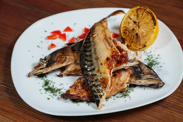 Beyaz bir plaka üzerinde ızgara sebzeli uskumru füme.