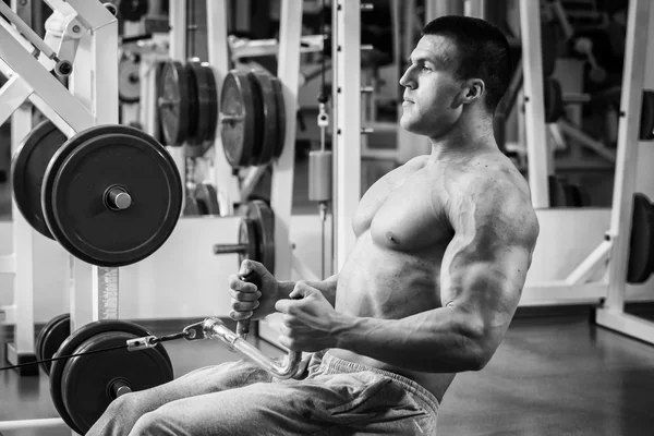 Strong muscular man doing exercises in the gym. — Stock Photo, Image