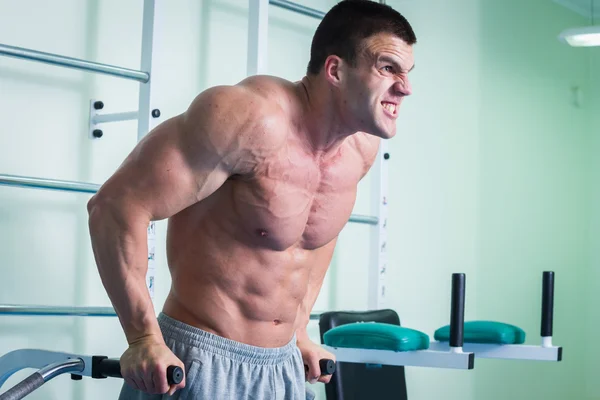 Homem musculoso forte fazendo exercícios no ginásio . — Fotografia de Stock