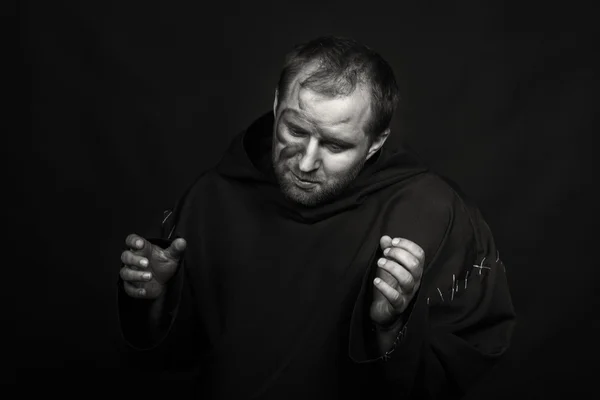 Ator de teatro de jogo bonito e fascinante na câmera. Foto em preto e branco do ator disfarçado de mendigo em um fundo escuro. Imagem de palco lindamente decorada e maquiagem profissional . — Fotografia de Stock