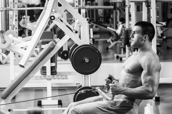 Homem musculoso forte fazendo exercícios no ginásio . — Fotografia de Stock