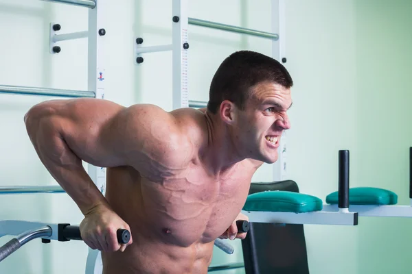 Silný svalnatý muž dělá cvičení v tělocvičně. — Stock fotografie