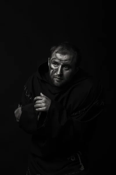 Beautiful and fascinating game theater actor on camera. Black and white photo of the actor in the guise of a beggar on a dark background. Beautifully decorated stage image and professional makeup.