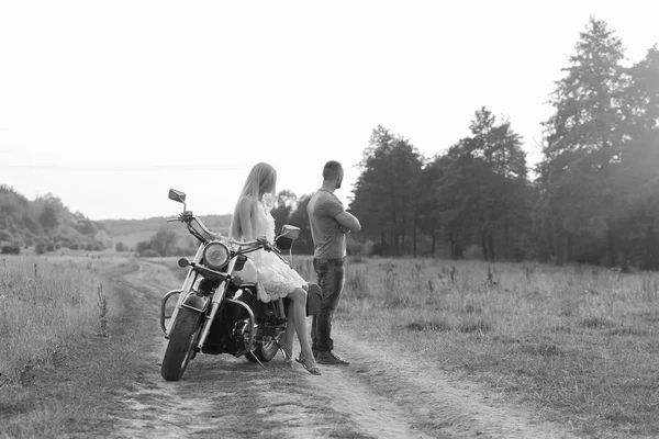 Black and white photo biker couple on a motorcycle in the field. — Stock Photo, Image