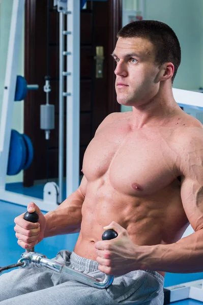 Homem musculoso forte fazendo exercícios no ginásio . — Fotografia de Stock